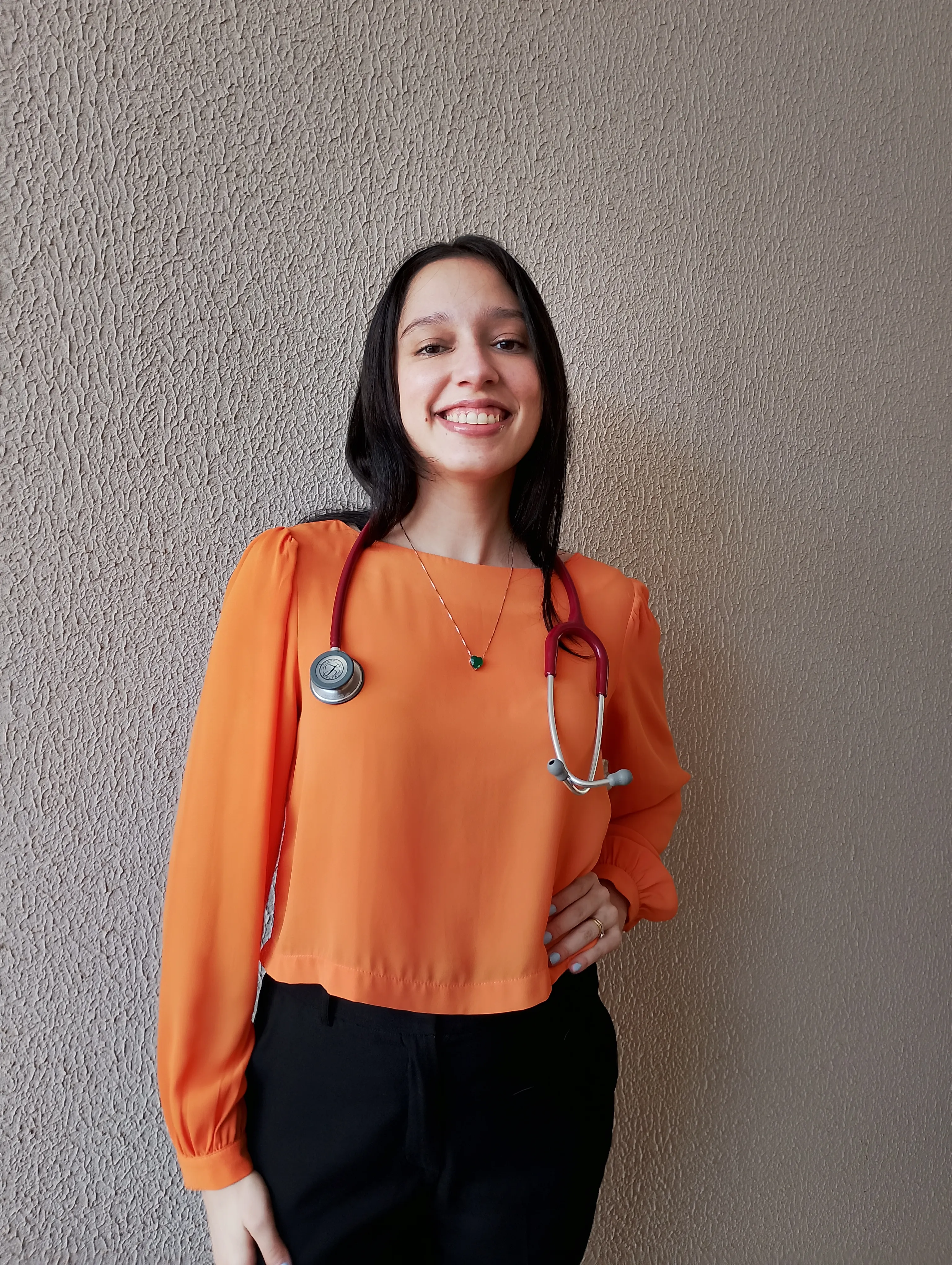 Dra. Andressa Paz sorrindo com estetoscópio